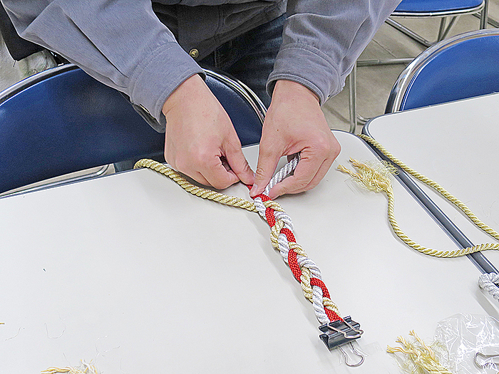 金や銀のキラキラとしたロープを使用し、三つ編みしてリースの形にしていきます。