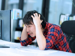 頭を抱えるエンジニア（写真はイメージです）