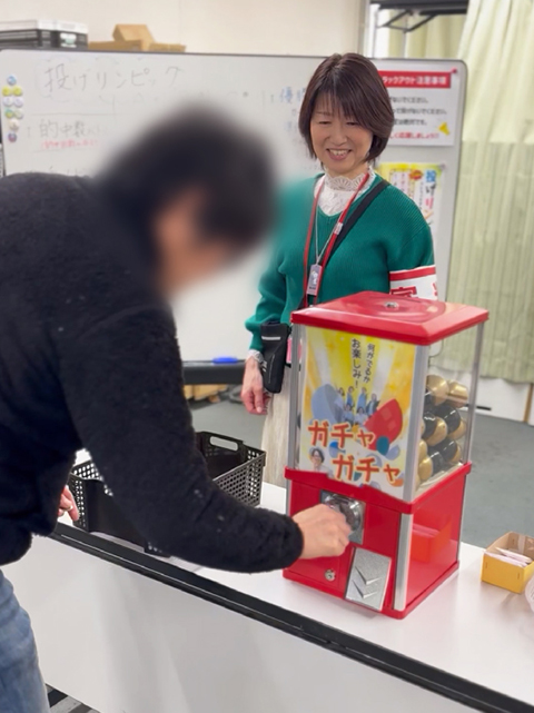 障害者雇用創造センターレクリエーション風景「投げリンピック」景品のガチャガチャを引く様子
