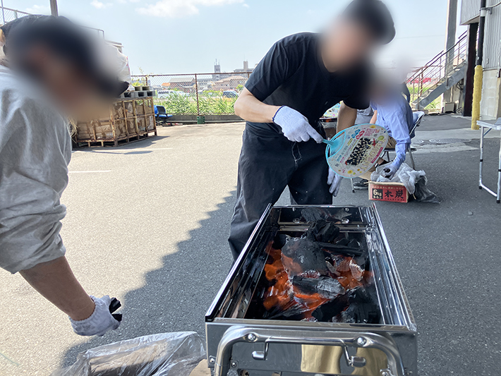 着火に成功し、炭が真っ赤に熾り、力強い炎が立ち上がり始めたBBQコンロのアップ。