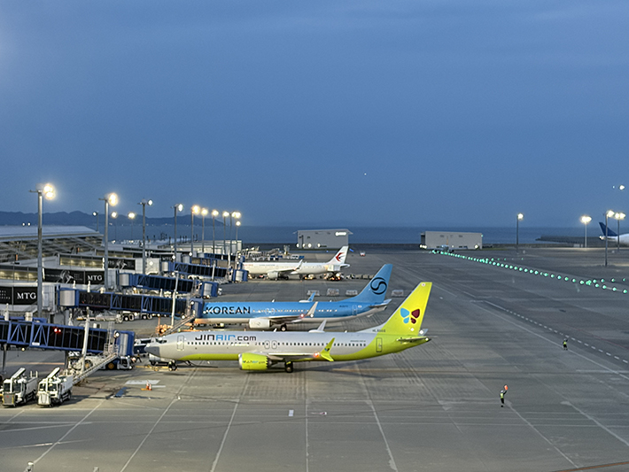 ジンエアー、大韓航空、中国東方航空の機体が並ぶ国際線駐機場。韓国や中国との活発な交流を象徴する、活気あるエプロンの様子。