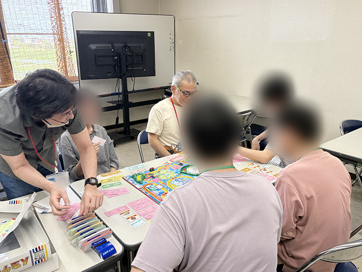 銀行役を務めるスタッフが、プレイヤーとの間で給料の支払いやイベント費用の徴収などを正確に行っている場面。