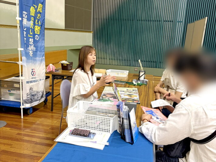 将来を見据え、熱心に質問をされる中学生・高校生の保護者様に対し、スタッフが資料を用いながら一人ひとりの悩みに寄り添い、IT訓練や就労支援の仕組みを詳しく説明している対話の風景。