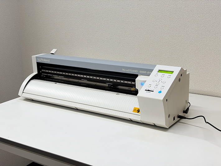 障碍者ITカレッジ愛西に導入された、ローランドDGの最新カッティングプロッター「VersaSTUDIO GS2-24」。看板やオリジナルグッズの制作を自社内で完結させるための、非常に頼もしい「モノづくりの相棒」としての佇まい。