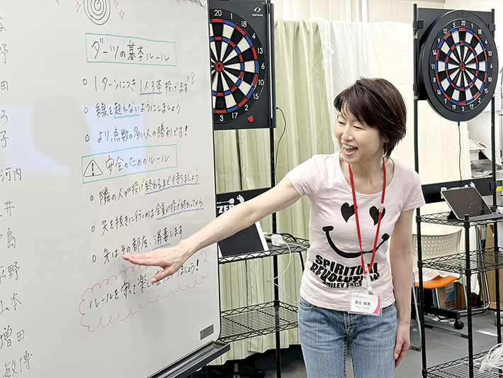 競技開始前、スタッフが訓練生全員へ向けてルールと安全上の注意（矢の扱い方など）を説明している様子。全員が安心して楽しむための「約束」を共有する、規律ある訓練風景。