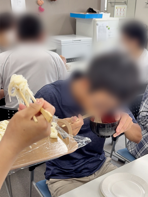 スタッフが次々と投入する麺に負けじと、一生懸命に「わんこ素麺」を食べ進める訓練生。仲間たちの「ドンドーン!」という掛け声に後押しされながら、農園直送の薬味の香りと共に、美味しさと楽しさが入り混じった賑やかな食事風景。
