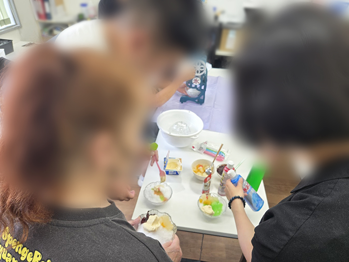 削りたての氷に、色とりどりのシロップや冷たいアイスクリームをトッピングする様子。いちごやメロンなど自分好みの味を組み合わせ、「オリジナルかき氷」を完成させる楽しみ。