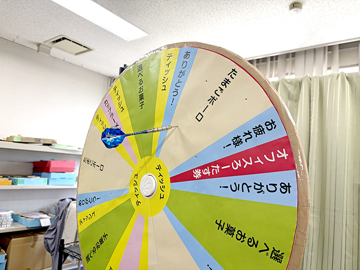 回転するルーレットの「たまごボーロ」の文字へ、ダーツの矢が正確に突き刺さった瞬間。