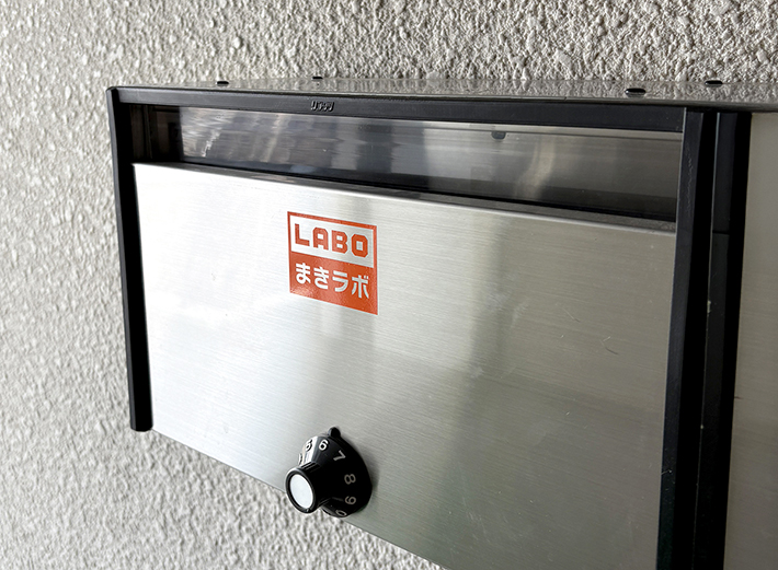「まきラボ」のポストに施工された、小さなサイズのカッティングステッカー。プロッターの高い精度を活かし、細かなデザインも崩すことなく、可愛らしく親しみやすいサインとして表現されています。