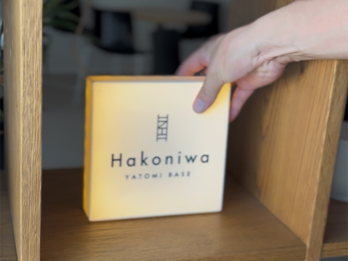 「Hakoniwa YATOMI BASE」のロゴを精密に刻んだ3Dプリンター製ライトボックス。明かりを灯すことでロゴがやわらかく浮かび上がり、トレーラーハウスのインテリアとしても機能する、実用性とデザイン性を兼ね備えた成果物。