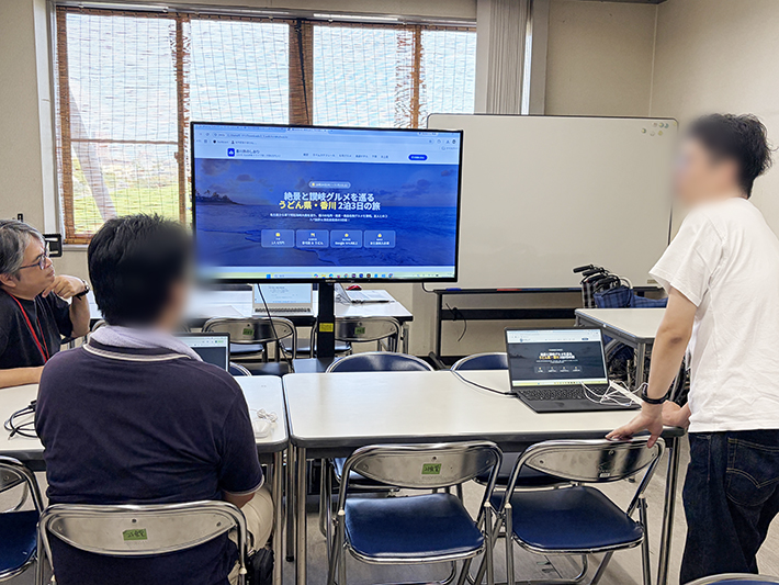 Geminiの「canvas（キャンバス）」機能を活用し、完成した個性あふれる旅行プランを文書やスライドのように美しく整理して発表する訓練生。 宿のランクを調整してお土産代を工夫するなど、こだわりが詰まった三者三様のプランをWeb上で見やすくまとめ、参加者同士で笑顔で成果を共有している発表風景。