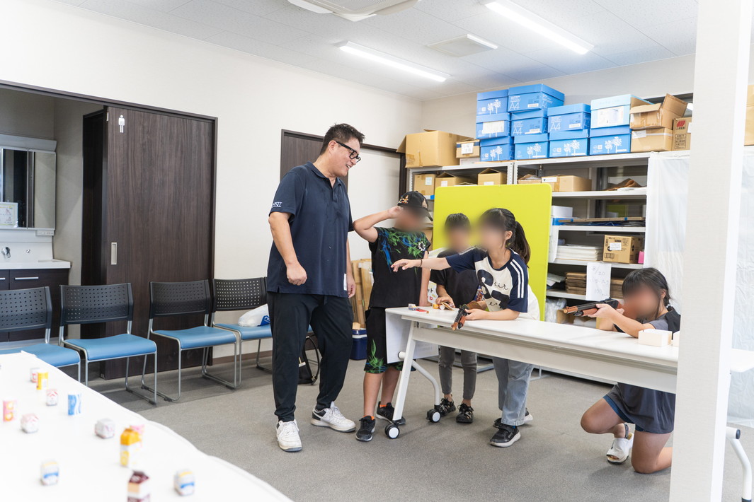 射的をする子供たちを見守る渡邉理事長