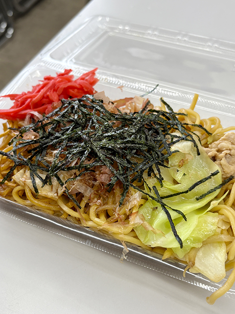 パックにたっぷり盛り付けられ、のりと紅生姜を添えて完成したお祭り屋台風のソース焼きそば。できたての熱々を笑顔で味わっていただくために、丁寧に盛り付けられた大満足のランチ。