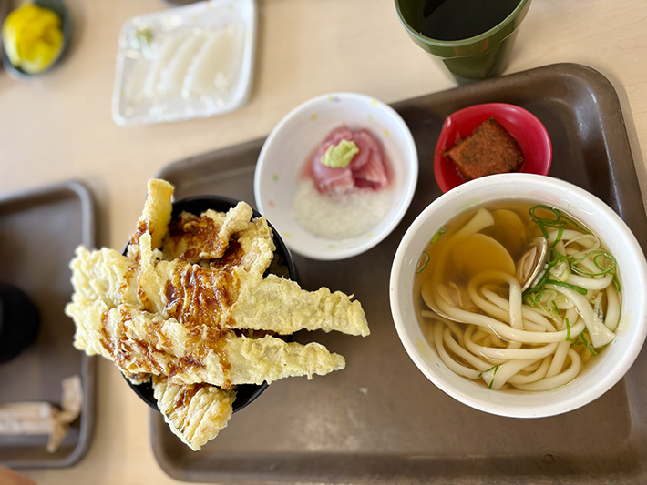 丼からはみ出すほど大きな穴子や魚の天ぷらが豪快に乗った天丼と、温かい貝だしうどんの定食セット。小鉢のまぐろ山かけやお漬物も添えられ、海鮮丼以外のメニューも豊富でボリューム満点な、まぐろレストランの魅力が詰まったお昼ごはん。