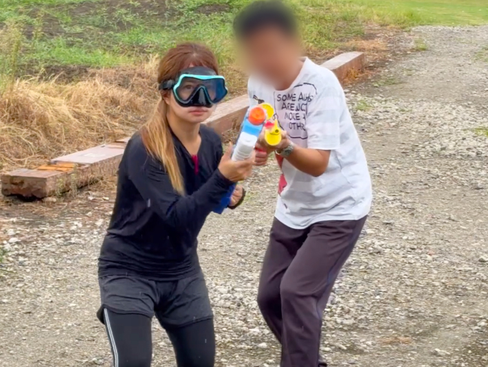 お互いに狙いを定めながらびしょ濡れになって水遊びを楽しむ、フレーベルの訓練生とスタッフ。夏の暑さを吹き飛ばすような、笑顔と元気な笑い声が会場いっぱいに響くレクリエーション中のひとコマ。
