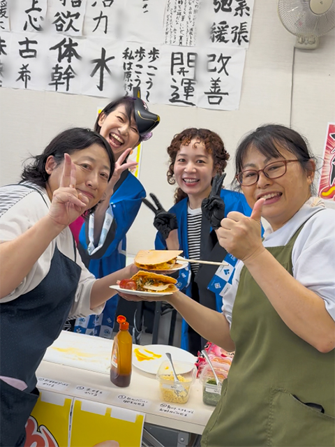 「縁日気分なゲームレク」を無事に大成功に導き、カメラに向かって満面の笑みでポーズを決める愛西事業所のスタッフ一同。 訓練生の「やってみたい！」や「楽しかった！」を全力で支える頼もしい支援員チーム。