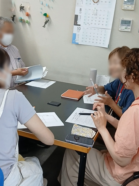 仲間からの発言や気づきを丁寧にメモしながら議論を重ねるグループ討論の様子。一人で抱え込まずチームで相談・解決する姿勢を深める研修のひとコマ。