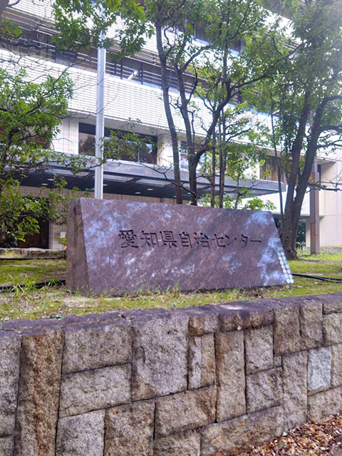 「高次脳機能障害者支援者養成研修」が開催された研修会場である「愛知県自治センター」の石碑銘板と建物外観。