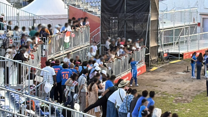 試合後、スタンドの柵から身を乗り出し、グラウンドの選手にサインを求めるファンたち