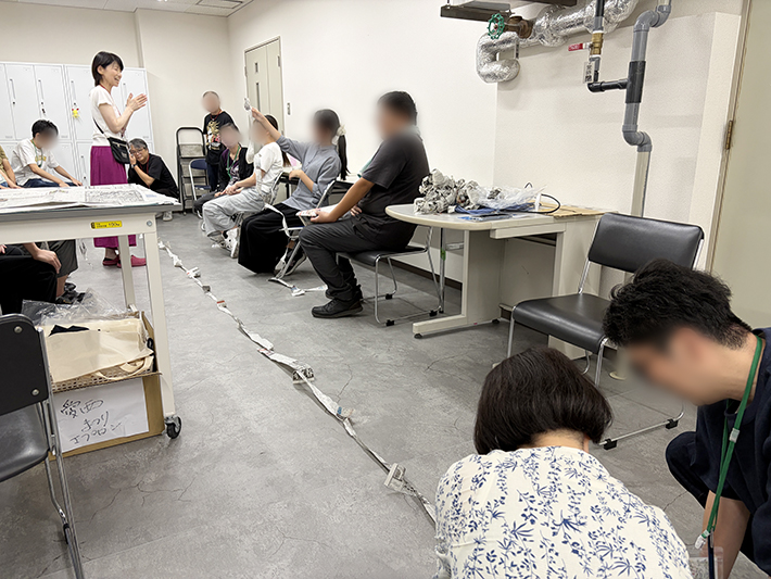 計測結果を見ながら参加者同士で工夫や良かった点を褒め合い、笑顔で振り返りを行う就労コミュニケーショントレーニングの様子。