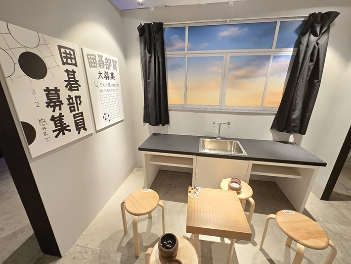 作中に登場する葉瀬中学校囲碁部の部室をリアルに再現した体験型展示コーナー。「囲碁部員募集」のポスターや碁盤・椅子が置かれた空間。